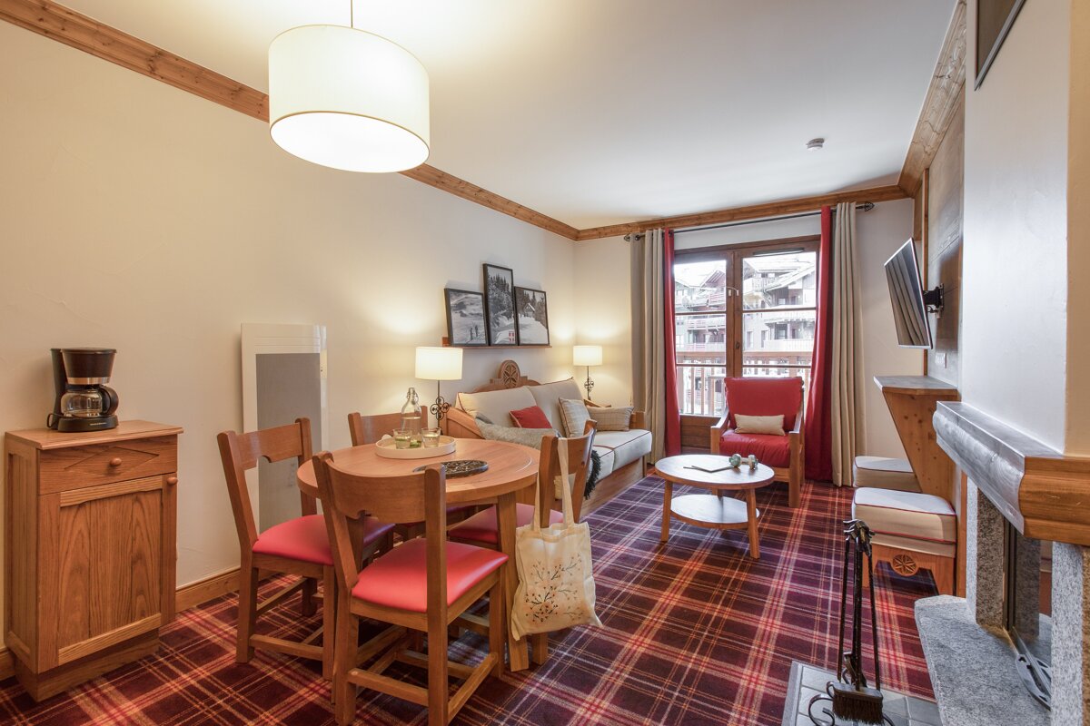 A living room with a table and chairs and a coffee maker
