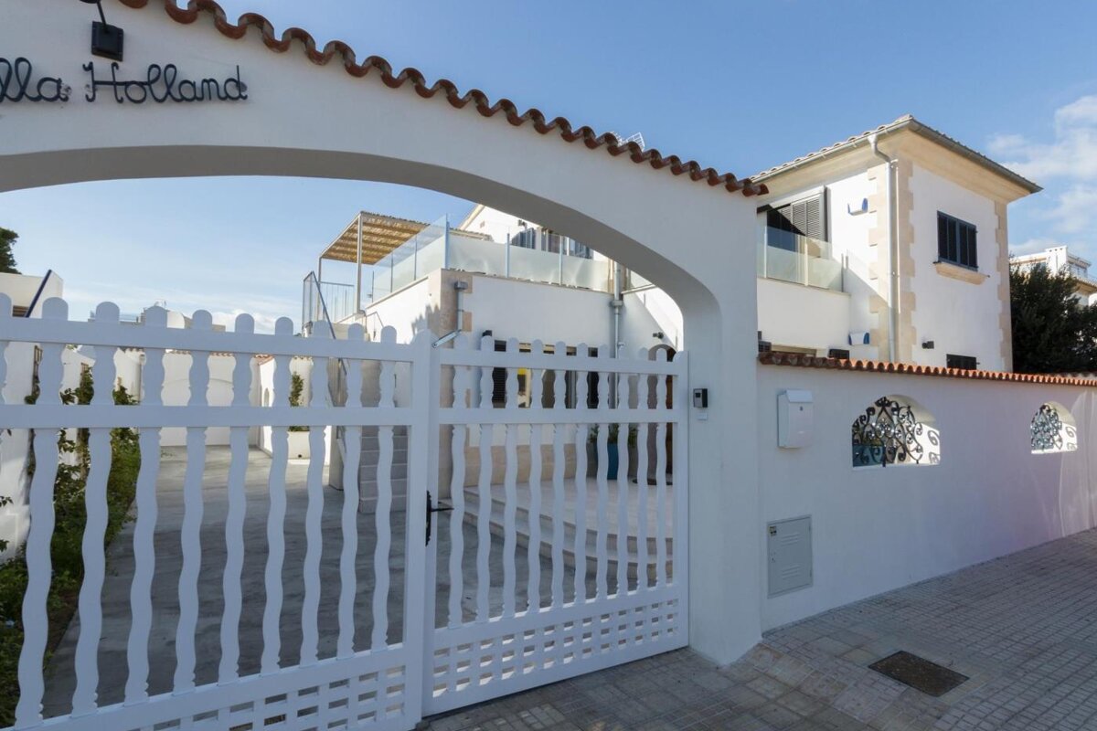 A white fence surrounds the entrance to villa holland