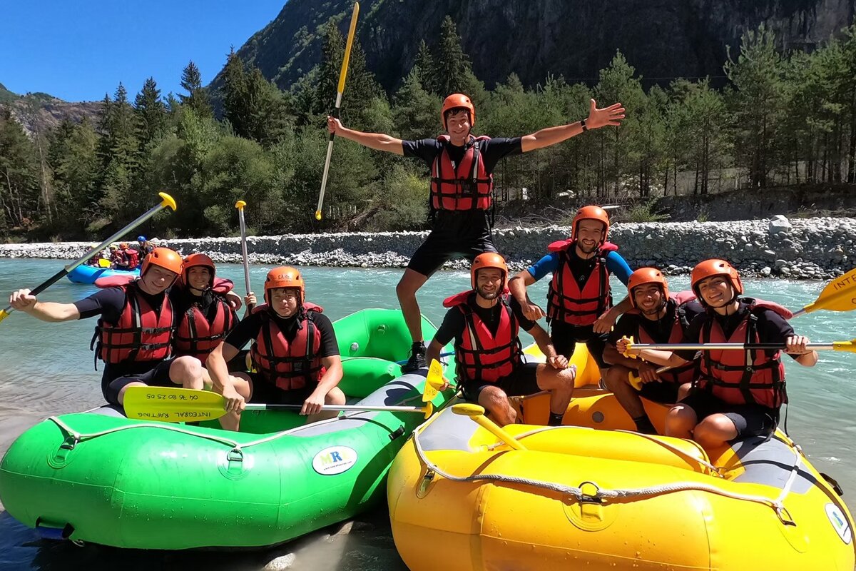 Two rafts with people in going rafting in the Venosc area on the Veneon river