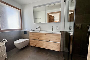 A bathroom with a toilet a sink and a mirror