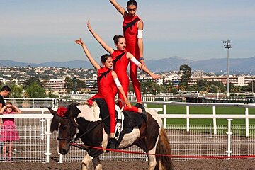 three women performing on a horse