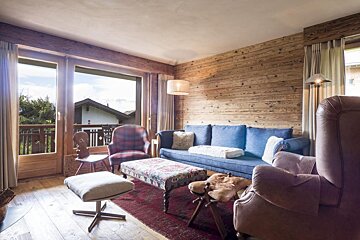 A living room with a blue couch and chairs