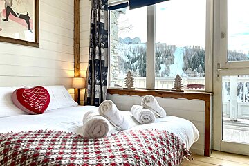 A bed with a heart shaped pillow that says love on it