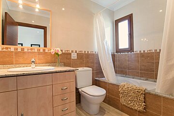 A bathroom with a toilet a sink and a window