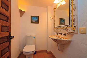 A bathroom with a toilet a sink and a mirror