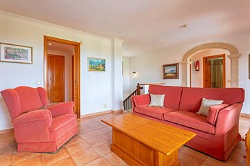 A living room with a red couch and two chairs