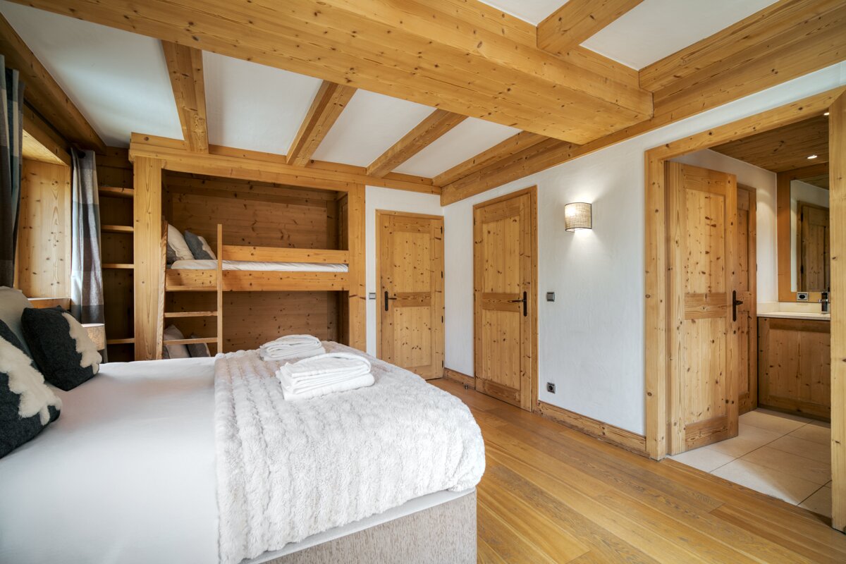 A bedroom with a bunk bed and a bathroom