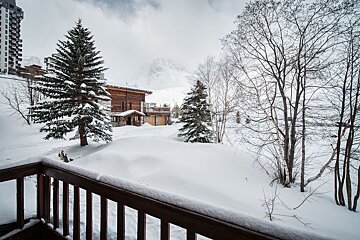A snowy landscape with a building in the background
