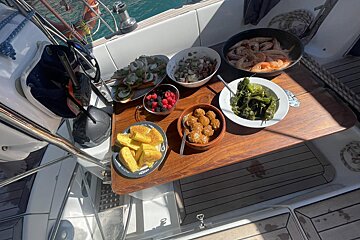 A wooden table with plates of food and a bowl of shrimp on it