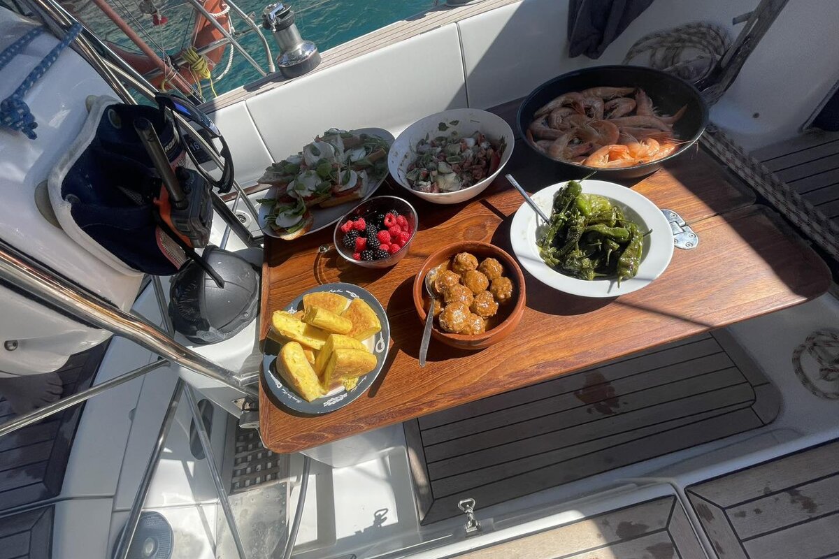 A wooden table with plates of food and a bowl of shrimp on it