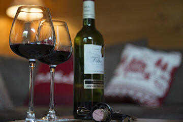 two glasses of wine and a bottle on a table