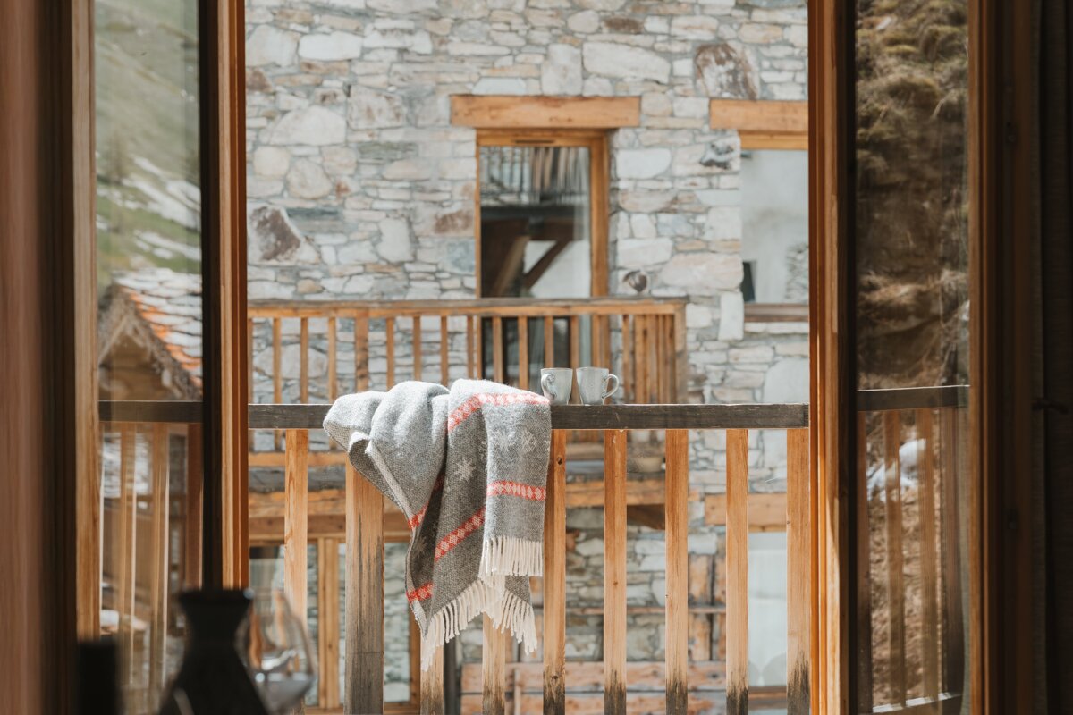 A balcony with a blanket and two cups on it