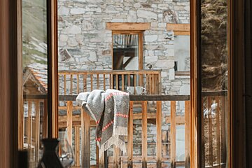 A balcony with a blanket and two cups on it