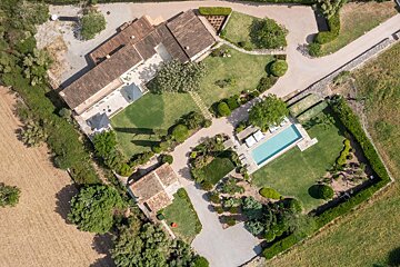 An aerial view of a large house with a swimming pool