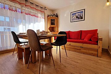 A living room with a table and chairs and a picture on the wall
