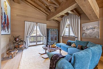 A living room with a blue couch and a painting on the wall