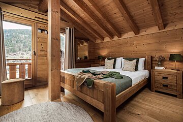 A wooden bedroom with a bed and two nightstands