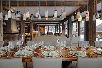 A dining room table with plates and glasses on it