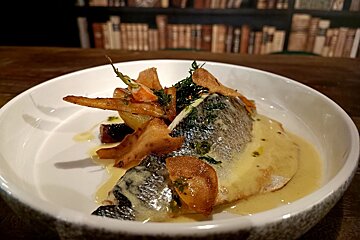 A white plate with a fish and vegetables on it