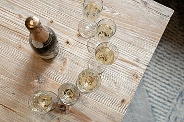 A bottle of champagne sits on a wooden table