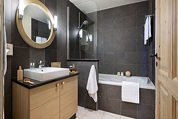 A bathroom with a sink a mirror and a bathtub