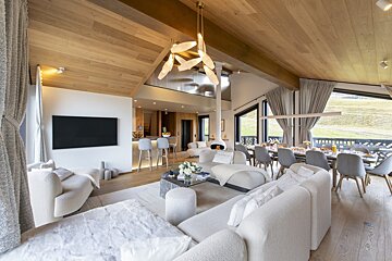 A living room with white furniture and a flat screen tv