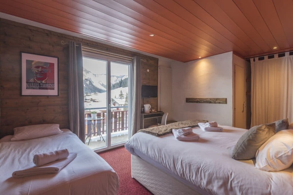 A room with two beds and a framed picture of a man named james fitzgerald