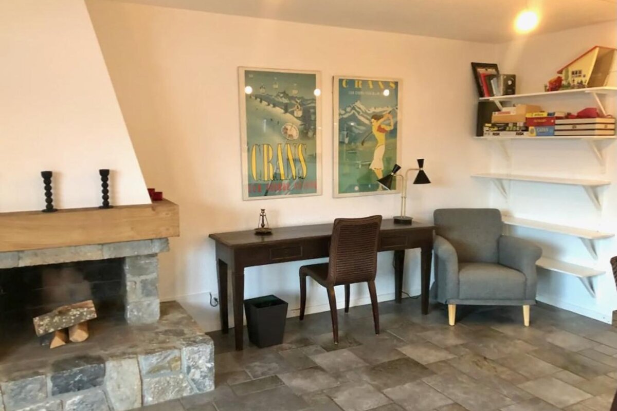 A room with a fireplace and a desk with a poster on the wall that says chass