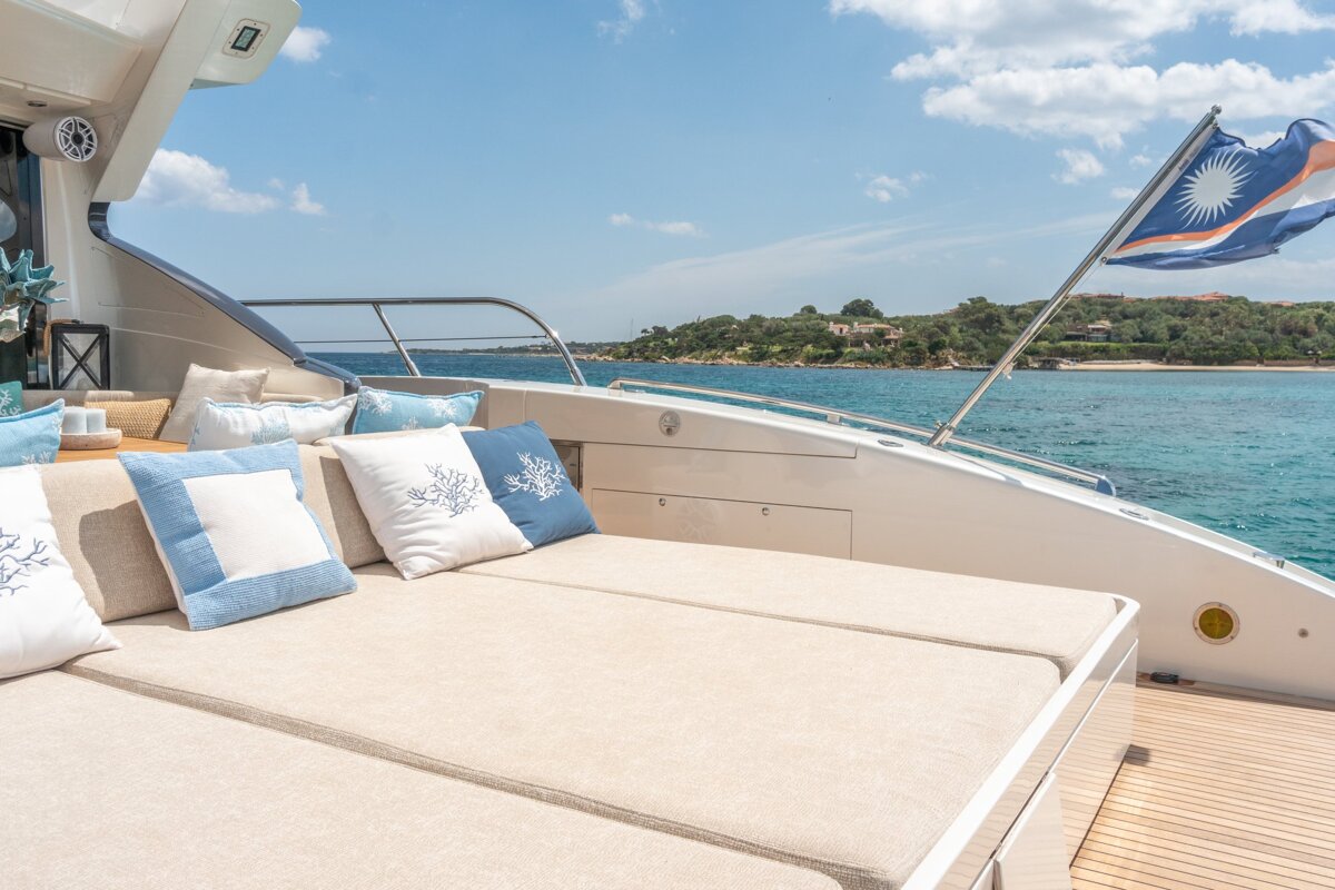 A couch on the back of a boat with blue and white pillows