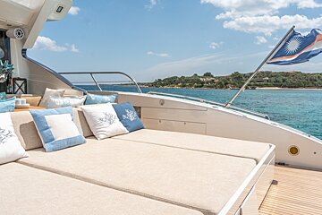 A couch on the back of a boat with blue and white pillows