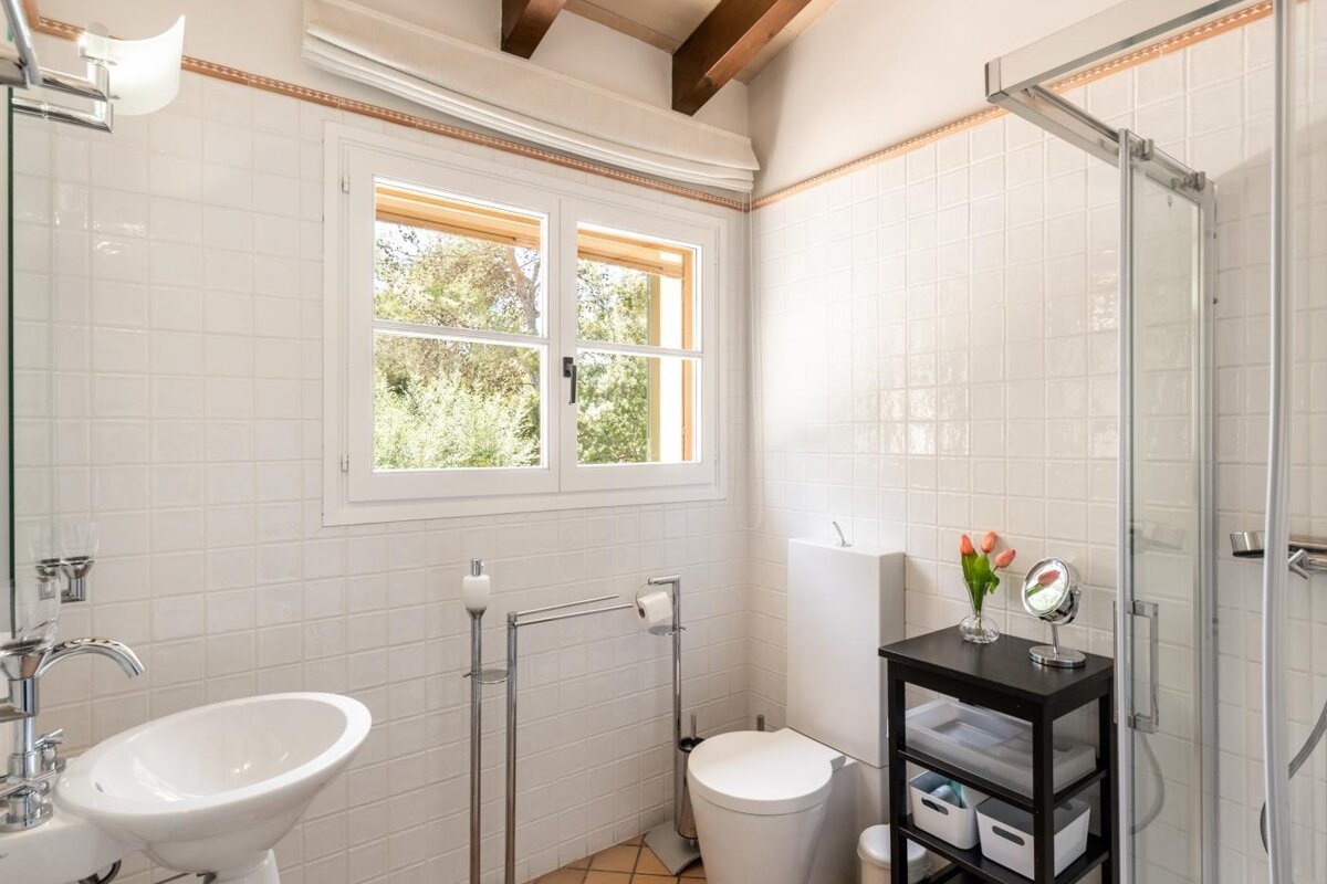A bathroom with a toilet a sink and a mirror