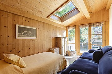 A bedroom with a single bed and a blue couch