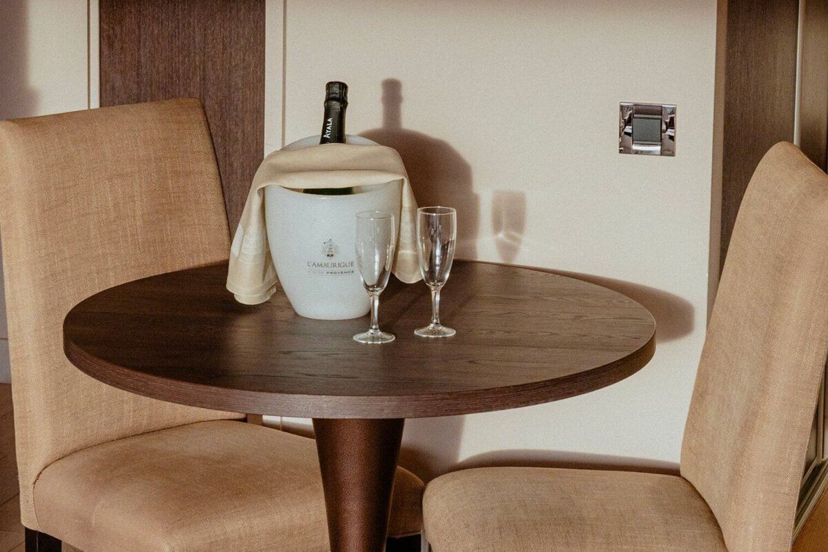 A bottle of champagne sits in a bucket on a table