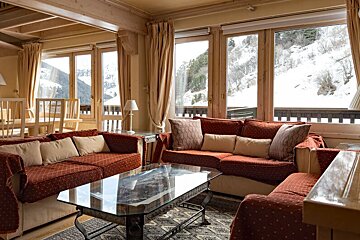 A living room with a red couch and a glass coffee table