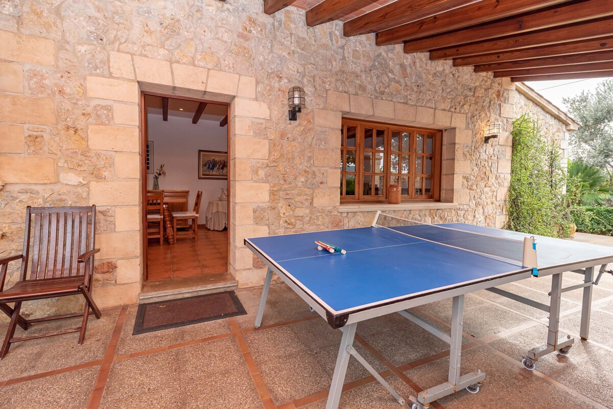 A ping pong table sits outside of a stone building