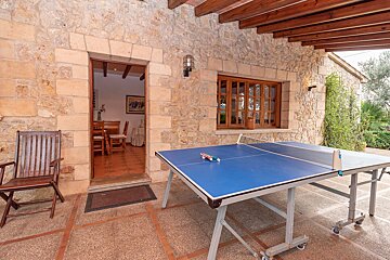 A ping pong table sits outside of a stone building