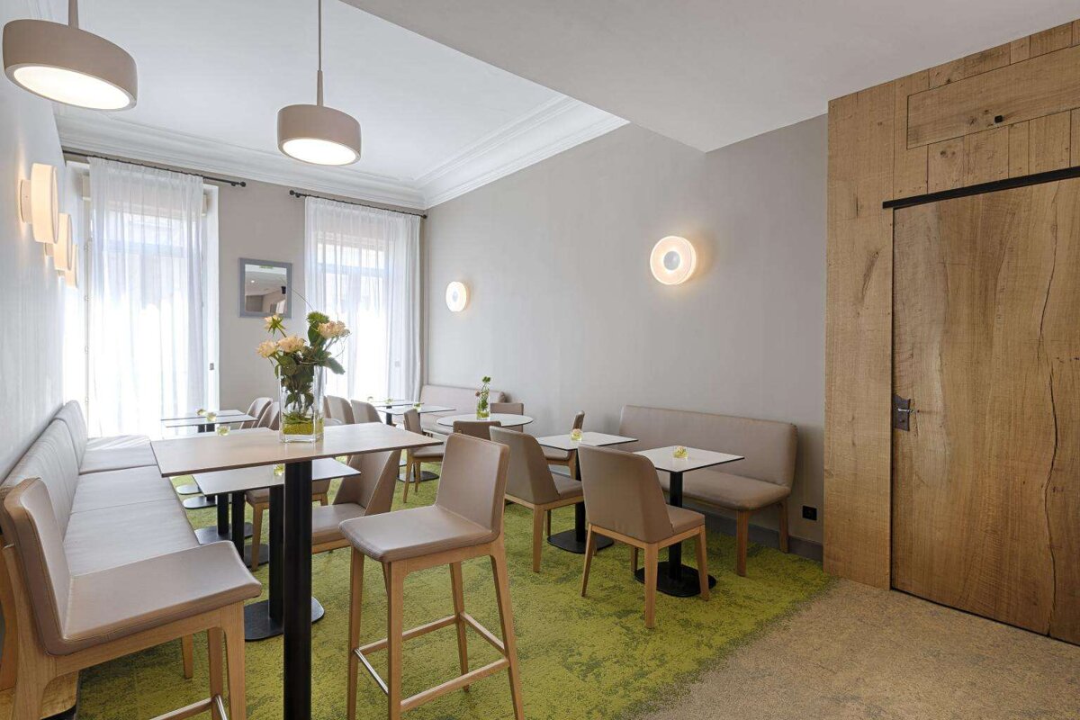 A room with tables and chairs and a green rug