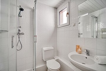 A bathroom with a toilet a sink and a shower