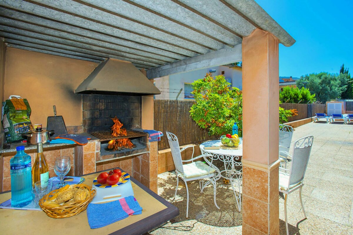 A bottle of aquafina sits on a table next to a grill