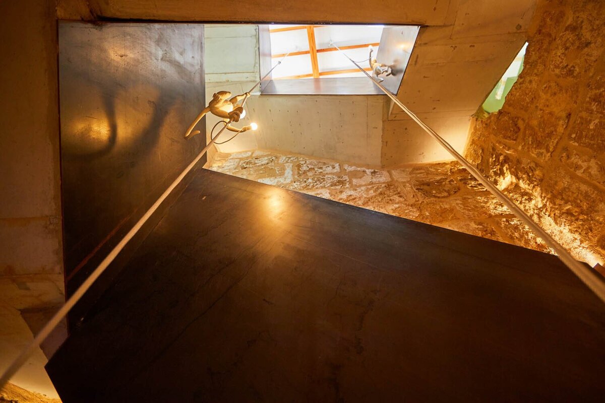 A staircase with a statue of a monkey hanging from it