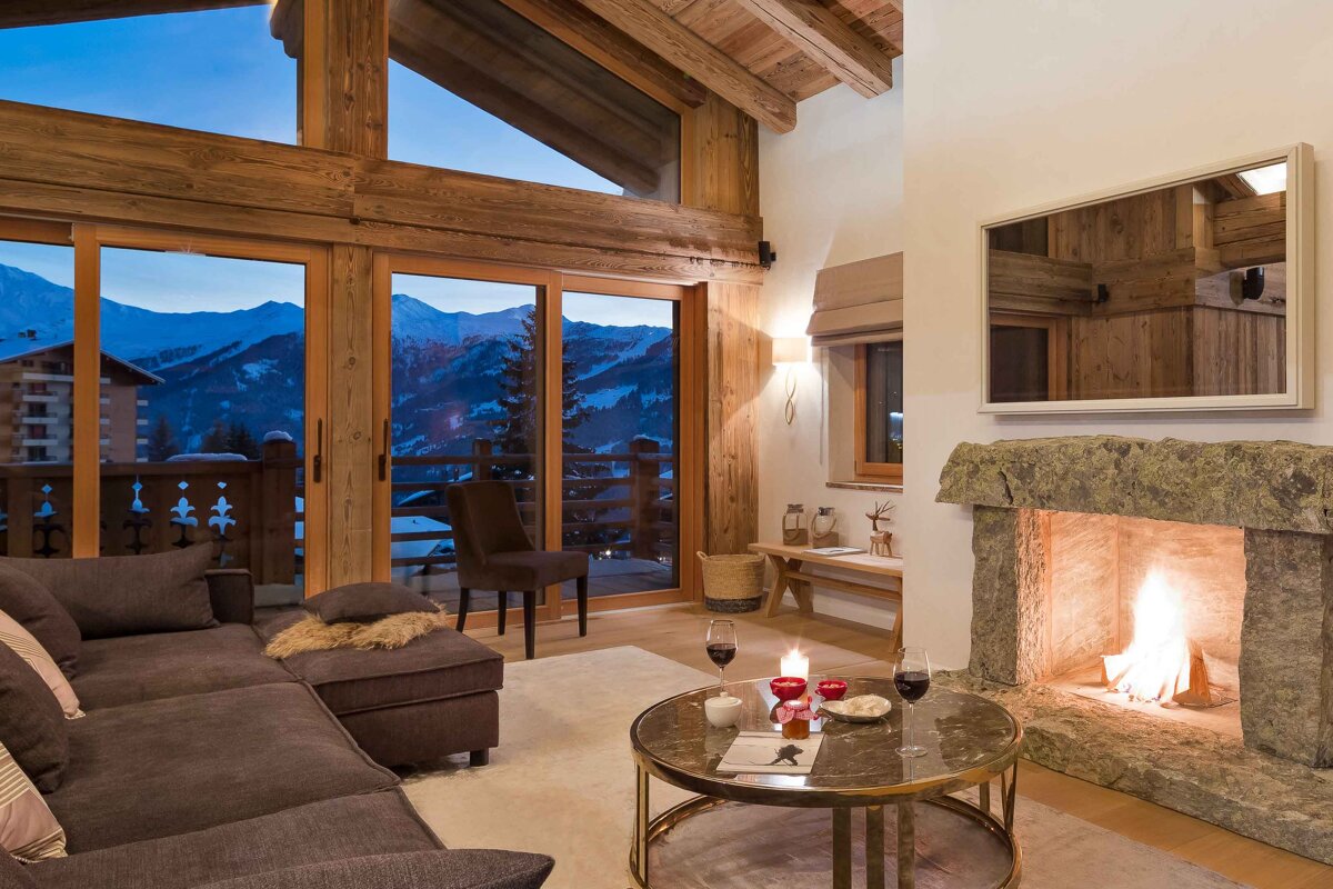 A living room with a fireplace and a view of the mountains