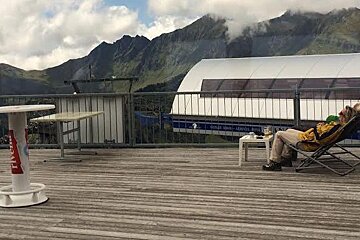 someone in a deck chair with a beer