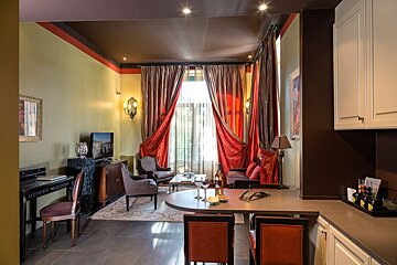 A living room with red curtains and a flat screen tv