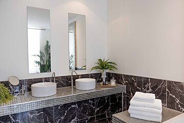 A bathroom with two sinks and two mirrors