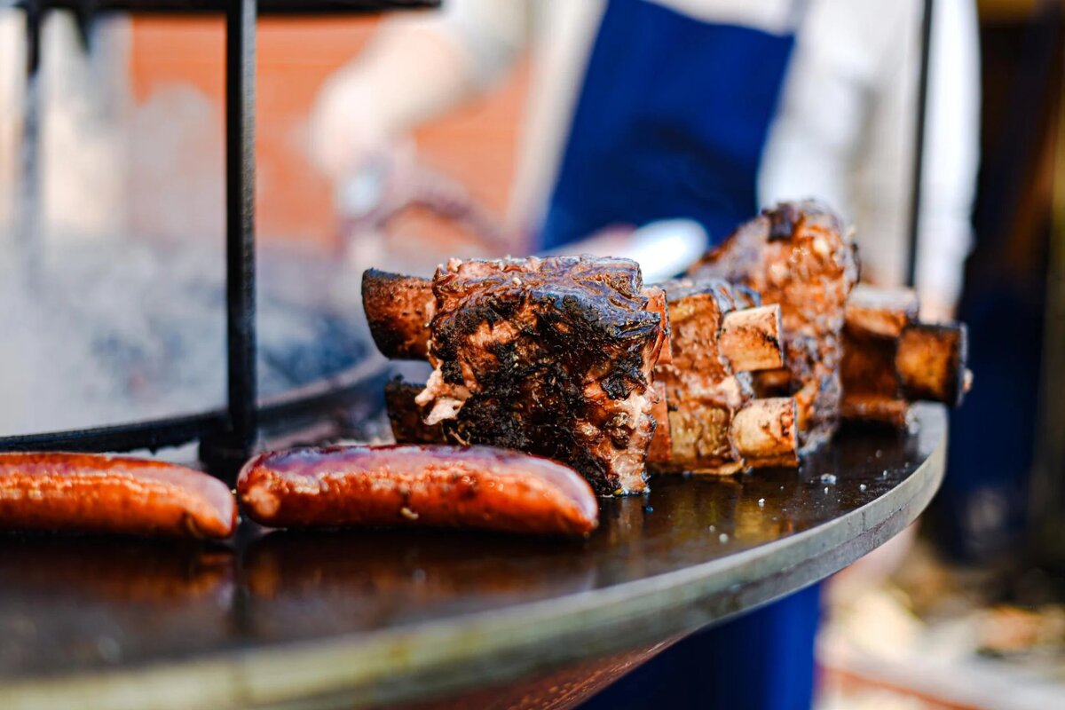 Ribs and sausages are being cooked on a grill