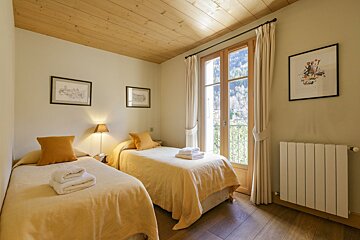 A bedroom with two twin beds and a radiator