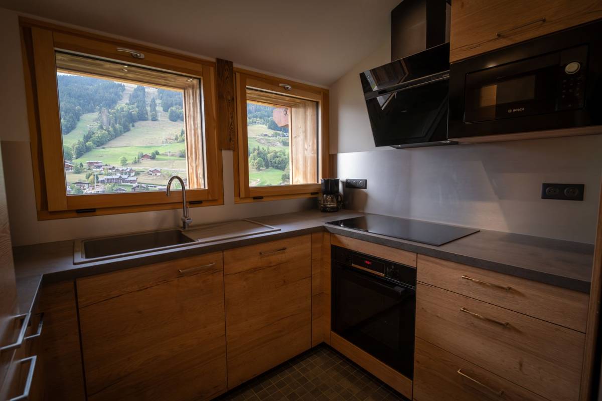 A kitchen with wooden cabinets and a bosch microwave