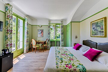 A hotel room with a large bed and a table