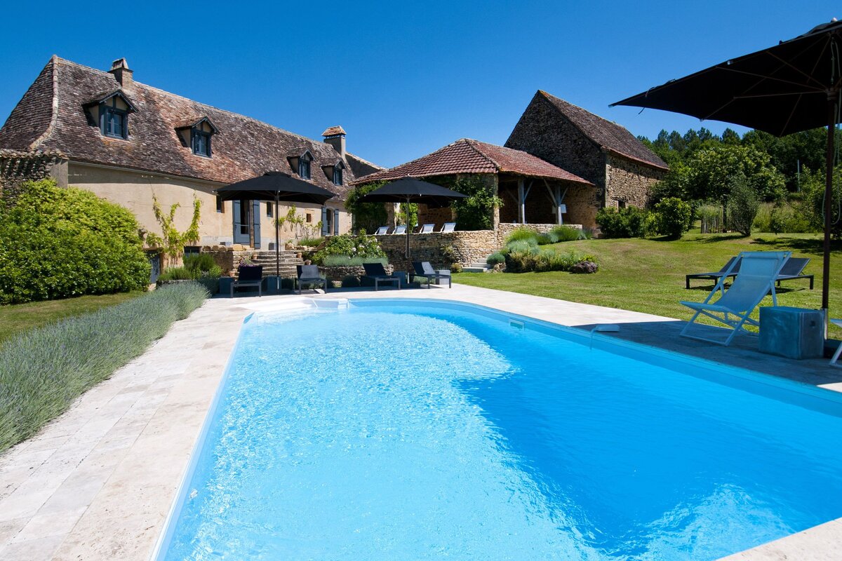 A large house with a swimming pool in front of it