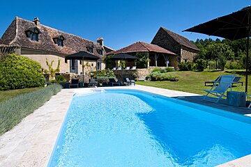 A large house with a swimming pool in front of it